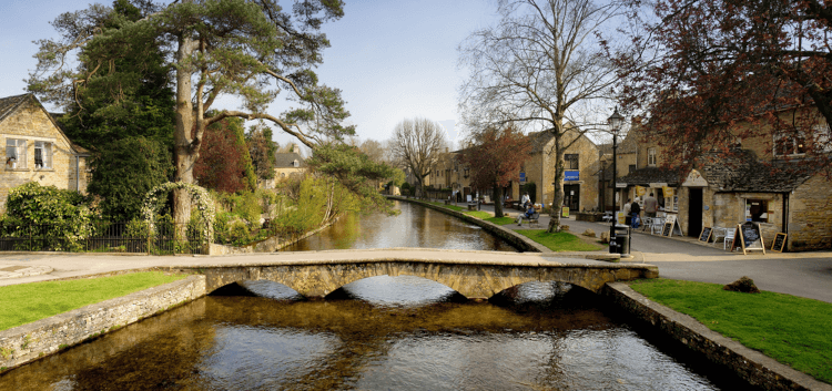 In Bourton-on-the-Water, a low three-arched bridge crosses the shallow waters of the river running through town.